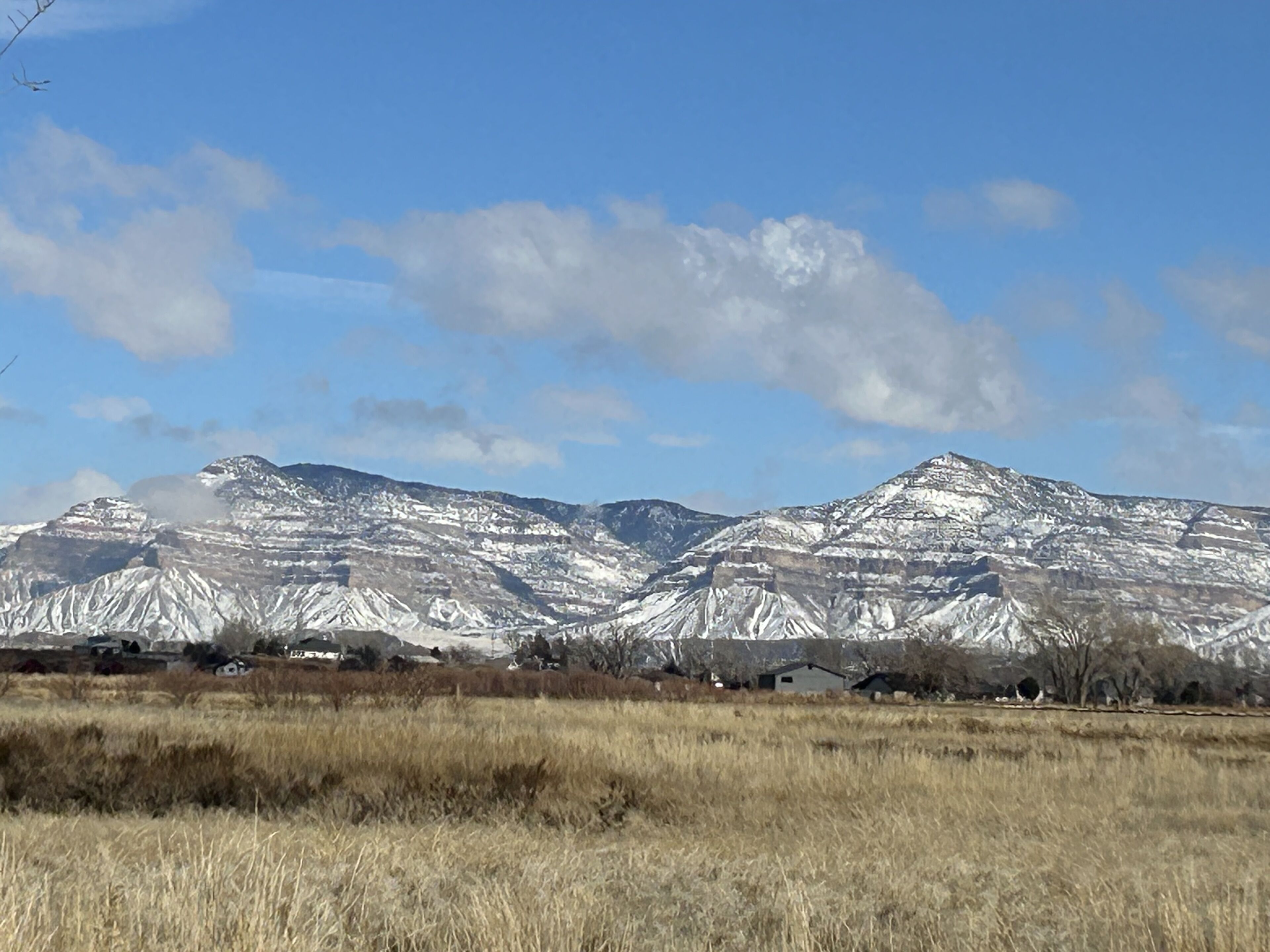 A mountainous landscape with snow-capped peaks and a clear sky.