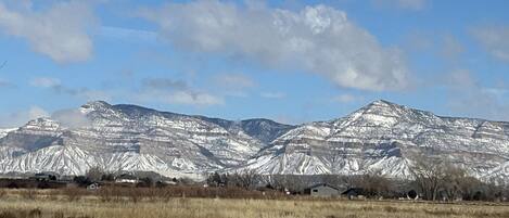 A mountainous landscape with snow-capped peaks and a clear sky.