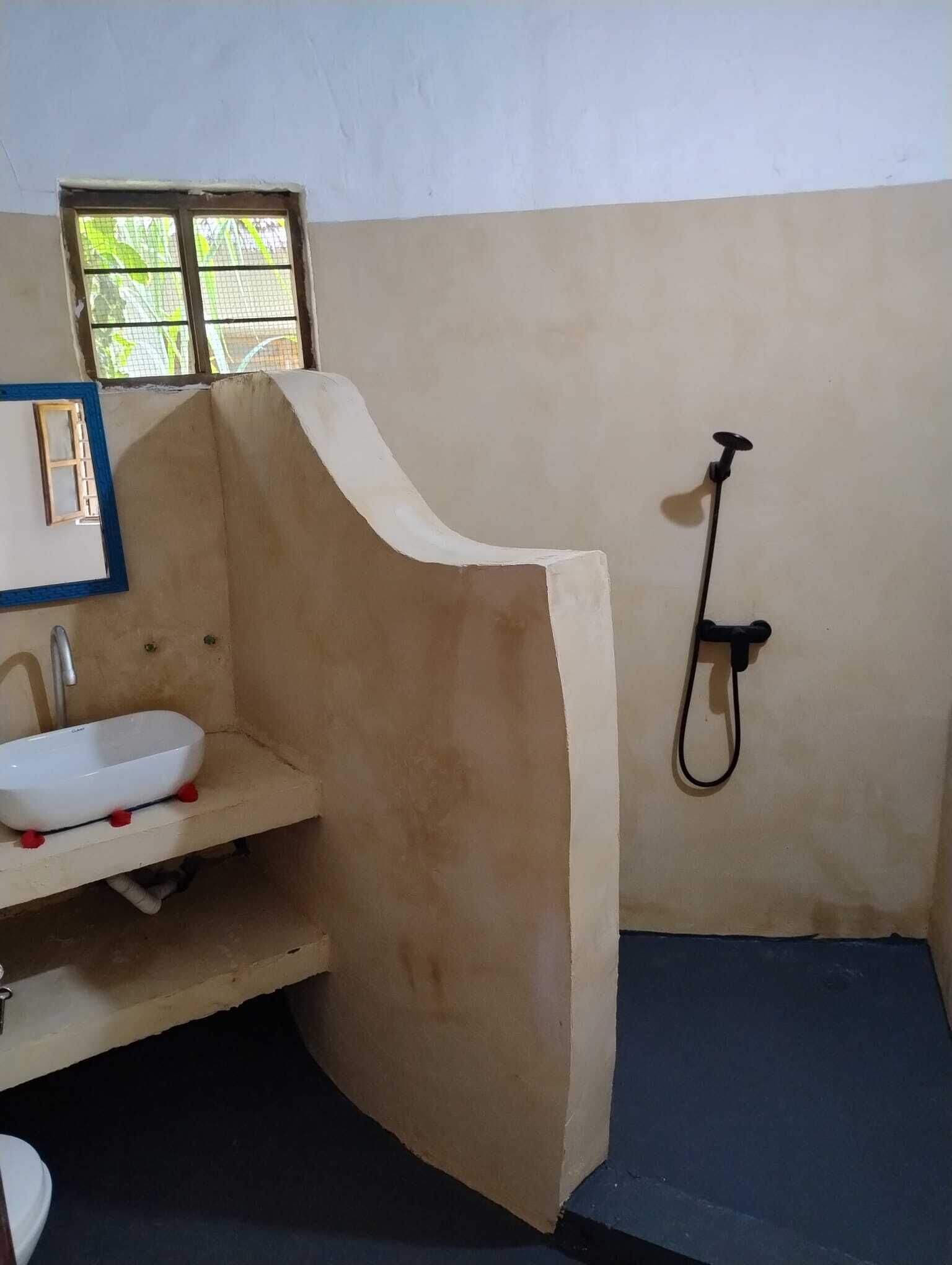 Un baño con lavamanos, ducha y ventana.