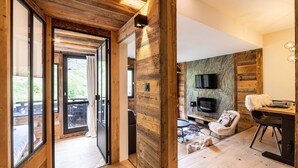 Un intérieur moderne agrémenté d’éléments en bois, un coin repas et un téléviseur fixé au mur.