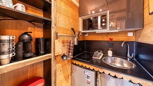 A compact kitchen with wooden cabinets, a microwave, a sink, and a coffee machine. - Immodreams - La Grange - Avoriaz (Avoriaz)