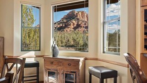 A room with a view of a mountain, a wooden cabinet, and two chairs. - Red Rock Bonanza +Hot Tub, Hikes & Views! (Sedona)