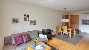 A modern living room with a sofa, a coffee table, and a dining area with a table and chairs. - Hölderle Damüls  - mountain view #11 (Damüls)
