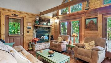 Cabaña, varias camas, hidromasaje | Área de sala de estar | Televisión de pantalla plana, chimenea y consola de videojuegos
