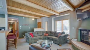 A living room with a sectional sofa, a glass coffee table, and a fireplace. - Amalia Mountain Getaway w/ Deck, Fireplace! (Amalia)