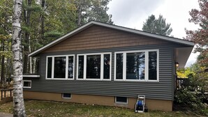 A two-story house with a sloped roof and multiple windows. - 4 Seasons Superior Beach House (Marquette)