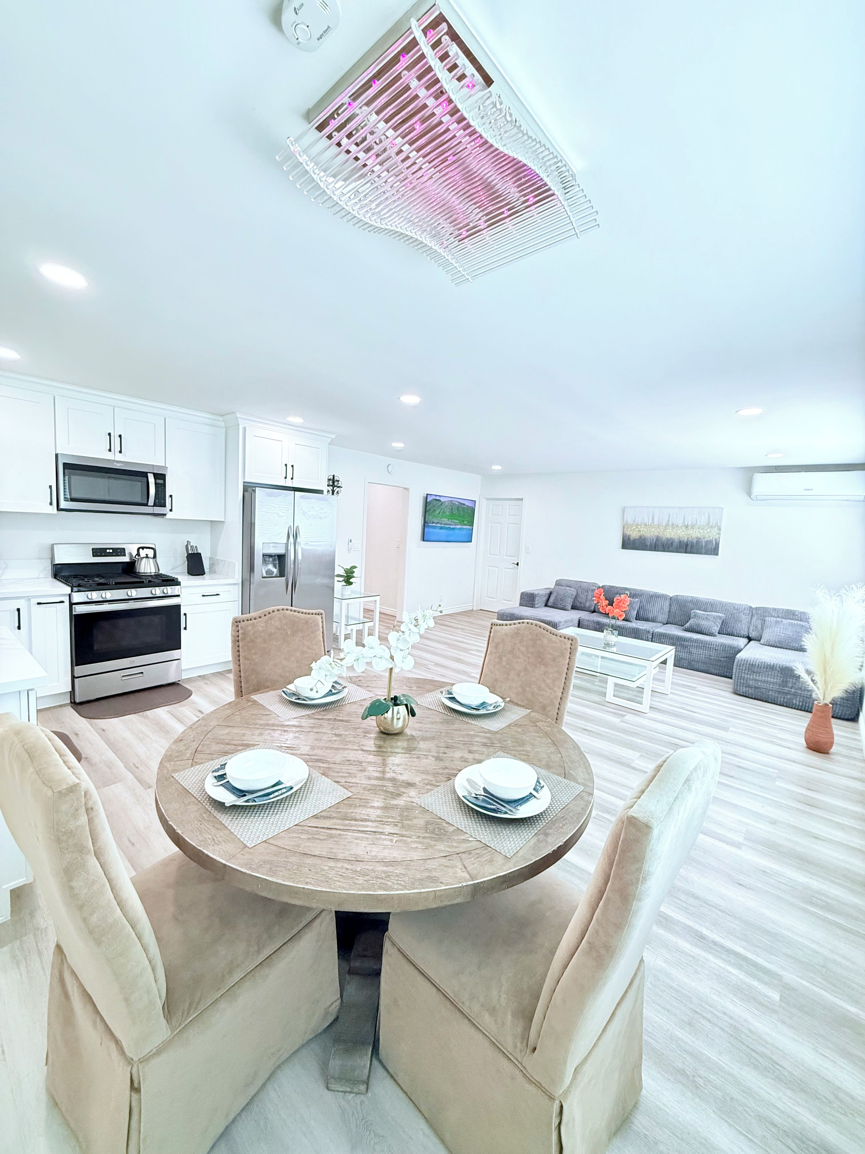 A modern kitchen with white cabinets, a stainless steel refrigerator, and a microwave.