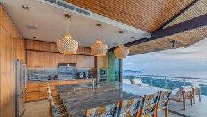Una cocina moderna con armarios de madera, una isla grande y lámparas colgantes.