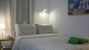 Ein Hotelzimmer mit einem Bett, einem Nachttisch, einer Lampe und einem Bild an der Wand.