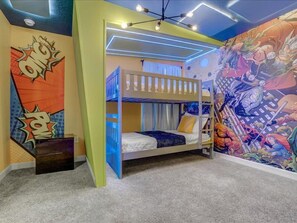 A bunk bed room with a mural, a ceiling light fixture, and a carpeted floor.