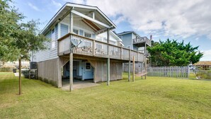 A two-story house with a covered porch and a fenced yard. - Frisco Coastal Paradise w/ Boat Dock & Water Views (Frisco)