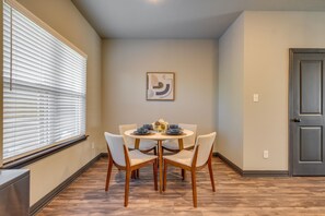 A dining area with a round table, four chairs, and a window with blinds. - Newly Built 'Corner Hideaway' 3 Mi to Texas A & M (College Station)