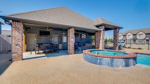 A covered patio area with a pool, outdoor seating, and a brick structure. - 'Corner Hideaway' 3 Mi to Texas A & M (College Station)