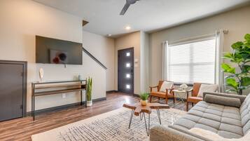 Un salon moderne avec un canapé, une table basse et un téléviseur fixé au mur.