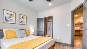 A bedroom with a bed, a door, and a bathroom visible through an open door. - 'Corner Hideaway' 3 Mi to Texas A & M (College Station)