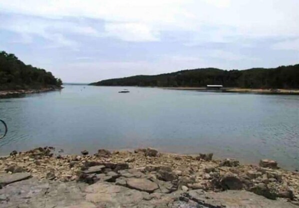 A river with boats, rocky shore, and forested banks.