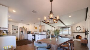 A spacious kitchen with modern appliances, a dining area with wooden furniture, and a cozy living space with a fireplace.