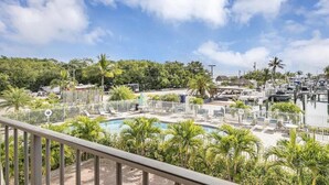 A resort with a swimming pool, lounge chairs, and a marina. - Beautiful Key Largo Condo with Direct Ocean Views (Key Largo)