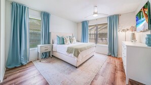A bedroom with a bed, nightstands, a dresser, and a ceiling fan. - Heated Private Pool, 5 Miles to Beach. Colorful, bright family-sized home.  (Vero Beach)