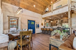 A spacious wooden interior with a dining area, kitchen, and seating.