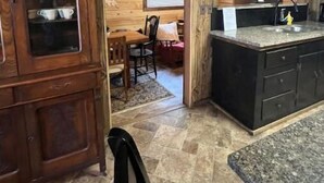 Une cuisine dotée de meubles en bois, d’un plan de travail en granit et d’un coin repas avec une table et des chaises.