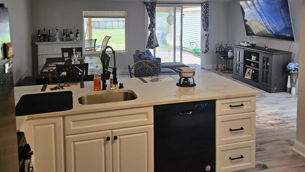 Una cocina moderna con una isla grande, electrodomésticos integrados y un comedor con vistas.
