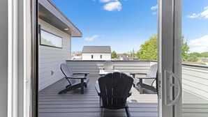 Une terrasse extérieure avec vue sur une maison, comprenant une table et deux chaises.