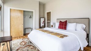 A bedroom with a large bed, a wooden door, a wardrobe, and a ceiling fan. - Rooftop Lounge ~ Sleeps 12 ~4 bed (Nashville)