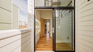 A narrow corridor with wooden flooring leading to a glass door. - Rooftop Lounge ~ Sleeps 12 ~4 bed (Nashville)