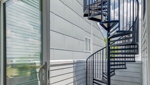 Eine moderne Außenterrasse mit Glastür zu einem überdachten Patio.