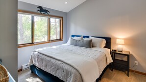 A bedroom with a large bed, a nightstand with a lamp, and a window with blinds. - 6 Mi to Winter Park: Mtn-View Condo w/ Balcony! (Fraser)