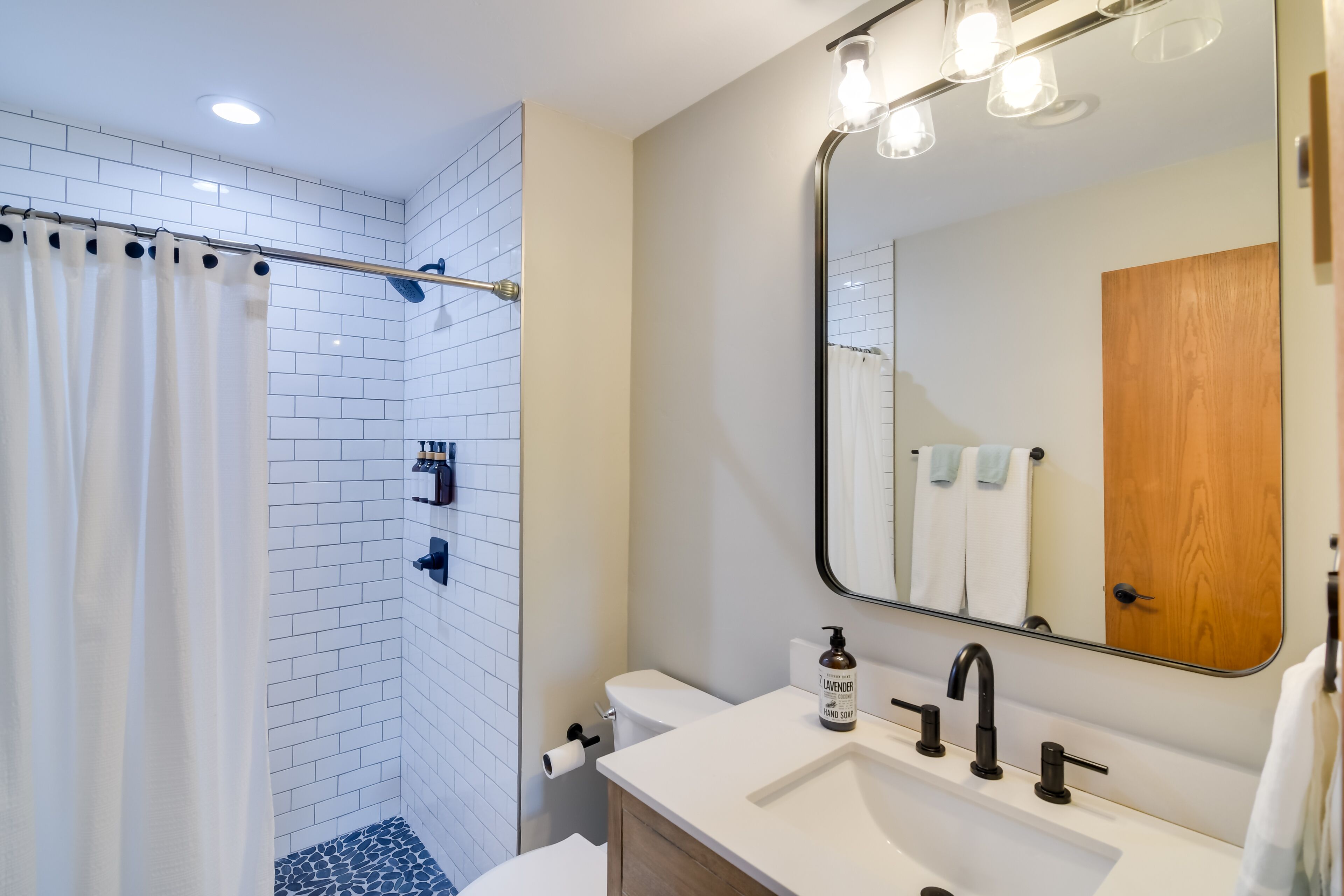 Une salle de bain moderne équipée d’une douche, de toilettes et d’un lavabo.
