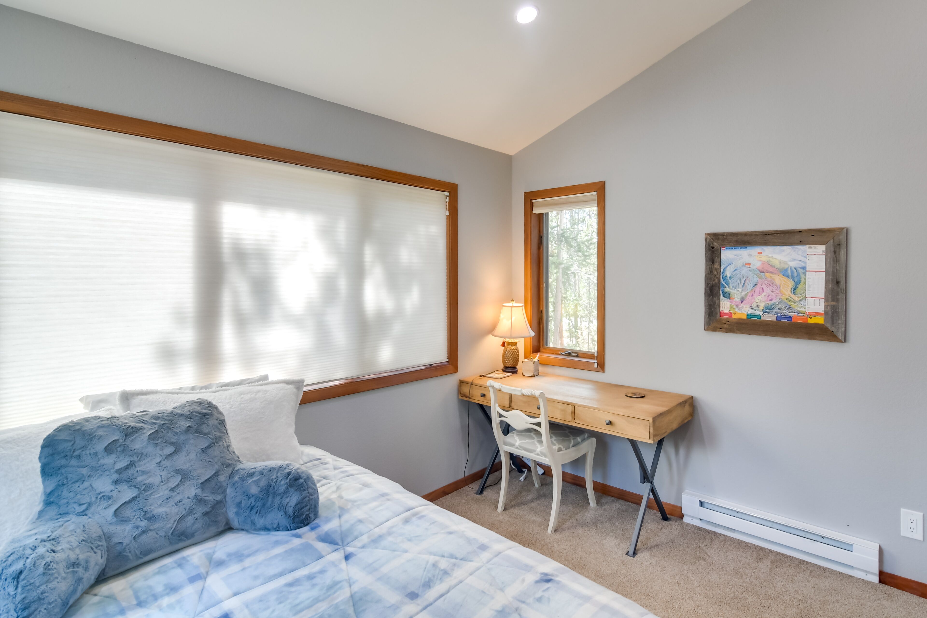 Une chambre à coucher comprenant un lit, un bureau, une chaise, une lampe et un calendrier fixé au mur.