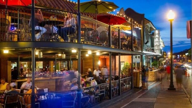 Ein Restaurant mit Außenbereich, einer überdachten Terrasse und Lichterketten.