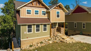 A two-story house with a front porch, stone steps, and a small front yard. - Pirates Peak (Gatlinburg)