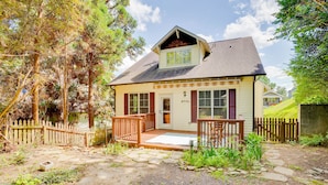 A two-story house with a front porch, a small deck, and a stone pathway leading to the front door.