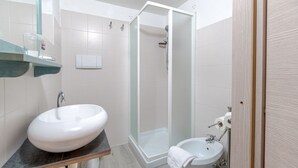 A bathroom with a large white sink, a glass-enclosed shower, and a small white basin. - GuestHost - Cozy apartment of 50 sqm, able to accommodate up to 4 people, located on the first floor of a building without elevator. The location is great! We are about 300 meters from the Cathedral of San Lorenzo, 200 meters from Palazzo Ducale , 600 fr (Genova)