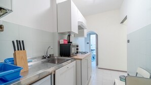 A modern kitchen with white cabinets, a stainless steel sink, and a coffee machine. - GuestHost - Cozy apartment of 50 sqm, able to accommodate up to 4 people, located on the first floor of a building without elevator. The location is great! We are about 300 meters from the Cathedral of San Lorenzo, 200 meters from Palazzo Ducale , 600 fr (Genova)