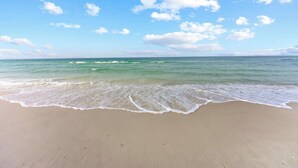 Une plage avec un ciel dégagé et des vagues douces.