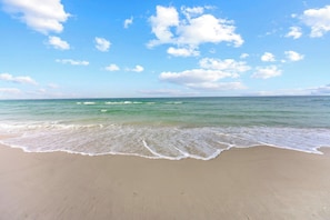 Une plage avec un ciel dégagé et des vagues douces.