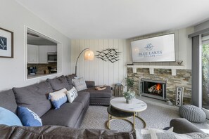 TV connectée, cheminée, livres, écrans d'ordinateur