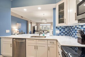 A modern kitchen with a stainless steel dishwasher, a built-in oven, and a microwave. - Atlantis 205B - Beachers Landing - Renovated (St. Augustine Beach)