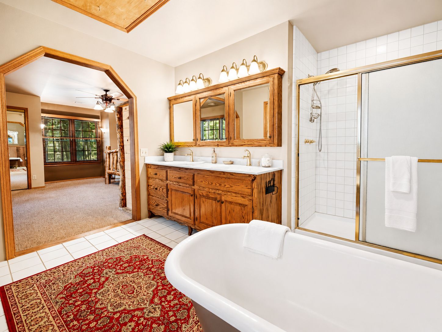 A spacious bathroom with a freestanding bathtub, a walk-in shower, and a large vanity with a mirror.