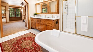 A spacious bathroom with a freestanding bathtub, a walk-in shower, and a large vanity with a mirror. - Starlight Summit (Big Bear Lake)