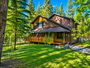 A cabin with a porch, surrounded by trees. - Starlight Summit (Big Bear Lake)