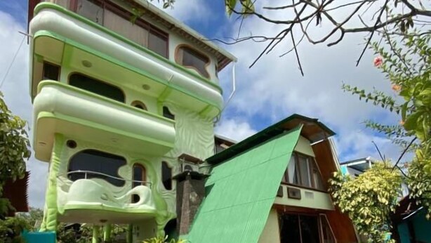 Um edifício moderno com design arquitetônico único, com vários níveis e um telhado verde.