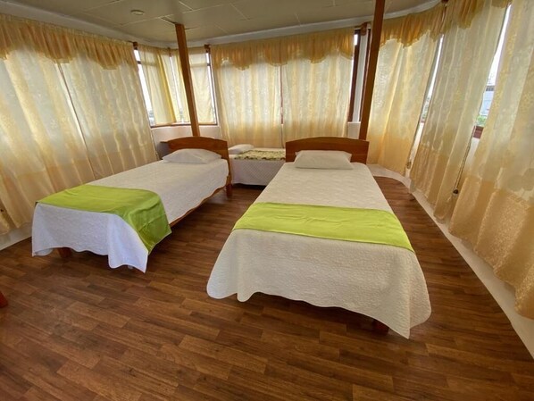 Una habitación con dos camas individuales, cabeceros de madera y piso de madera.