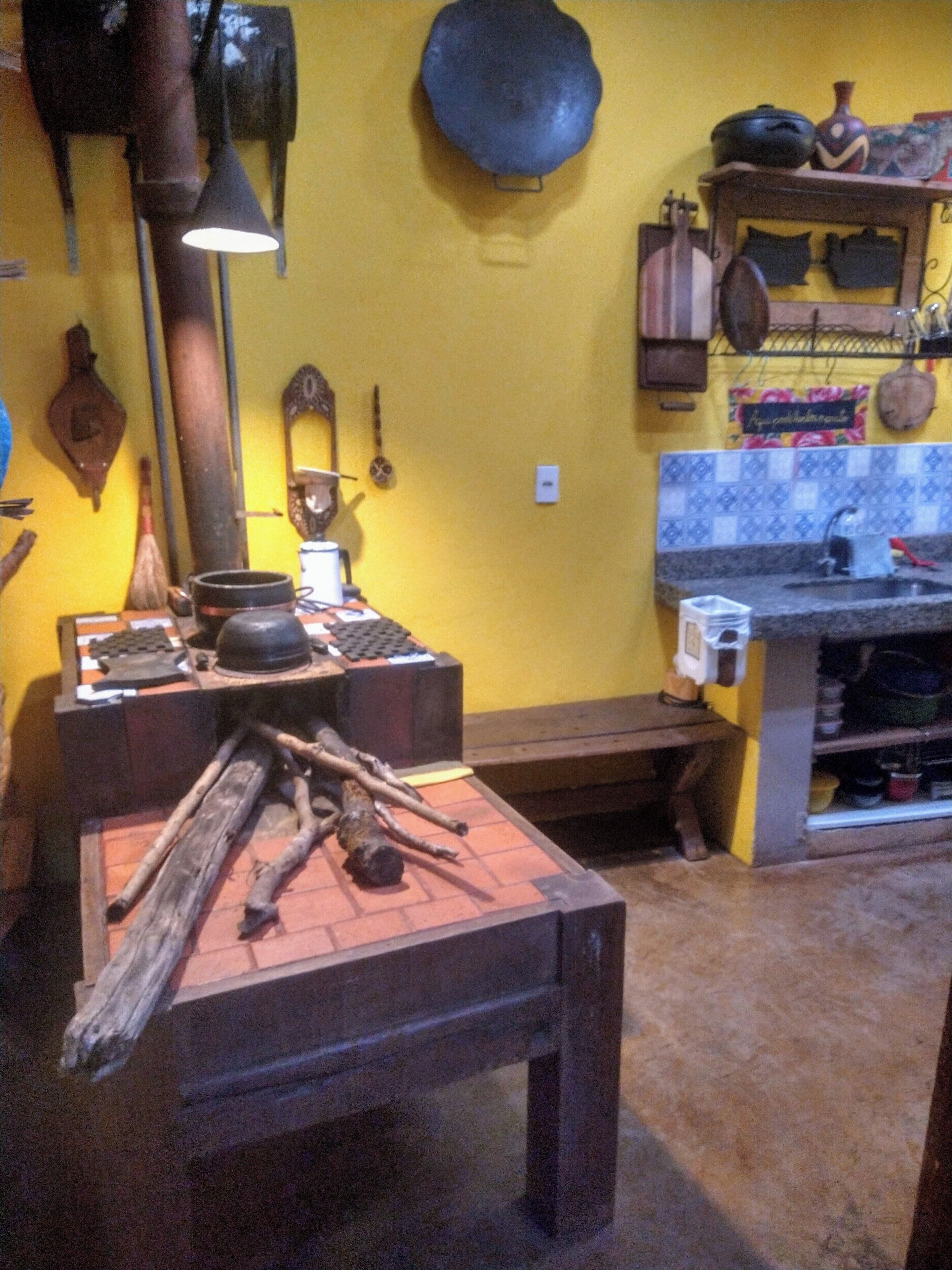 A kitchen with a stove, pots, and a hanging pot rack.