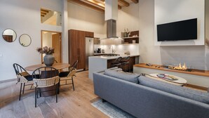 Una cocina moderna con una isla central, electrodomésticos integrados y un televisor de pantalla plana en la pared.