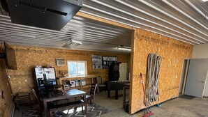 Un espacio interior amplio con techo alto, paredes de madera y suelo de concreto.
